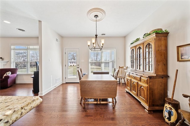 dining room with visible vents, baseboards, dark wood-type flooring, and an inviting chandelier