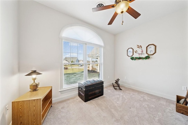 sitting room with ceiling fan, baseboards, and light carpet