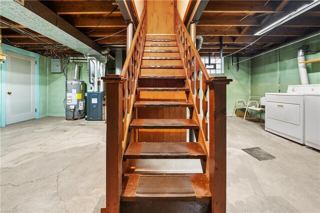 below grade area featuring washer and clothes dryer, stairway, and gas water heater