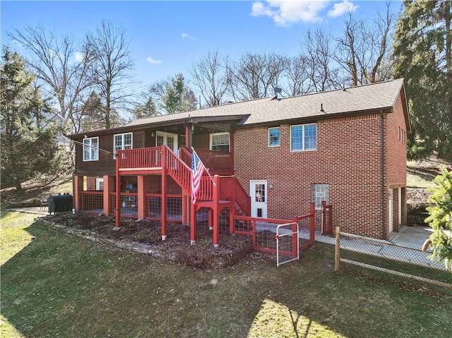 rear view of house featuring stairway, roof with shingles, a wooden deck, a yard, and brick siding