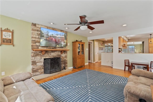 living area featuring a ceiling fan, wood finished floors, recessed lighting, a fireplace, and baseboards