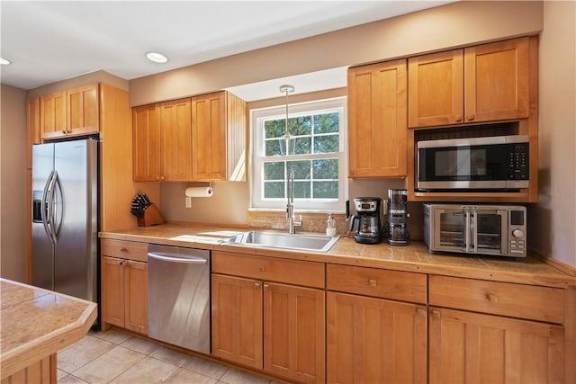 kitchen featuring a toaster, recessed lighting, light tile patterned flooring, stainless steel appliances, and a sink