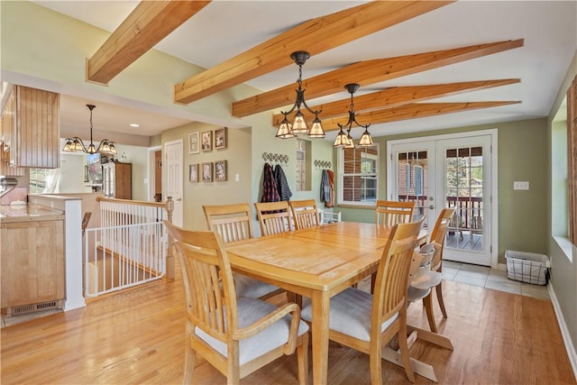 dining room with beam ceiling, an inviting chandelier, french doors, and light wood-style floors