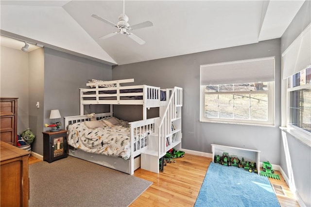 bedroom with vaulted ceiling, a ceiling fan, baseboards, and wood finished floors