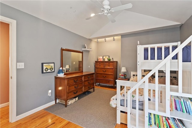 bedroom featuring lofted ceiling, light wood-style flooring, and baseboards