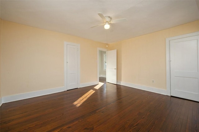 spare room with baseboards, wood finished floors, and a ceiling fan