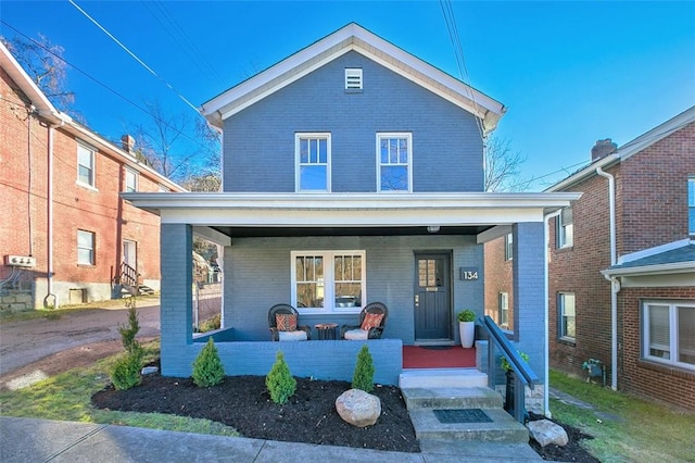 view of front facade featuring brick siding and covered porch