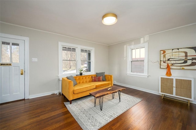 living room featuring dark wood finished floors, crown molding, and baseboards