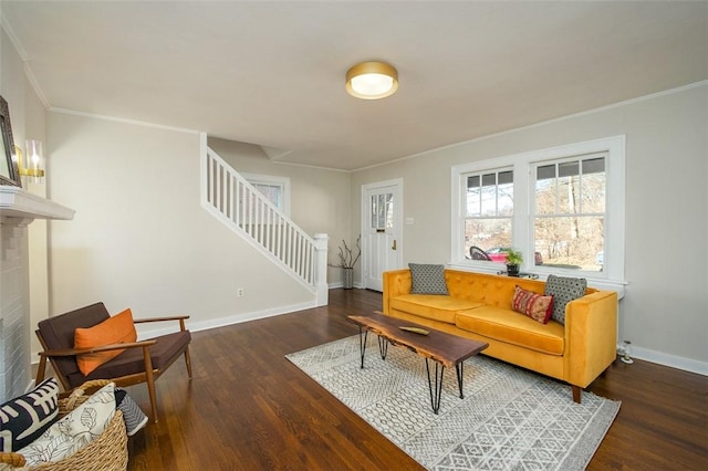 living room featuring crown molding, baseboards, stairs, a fireplace, and wood finished floors