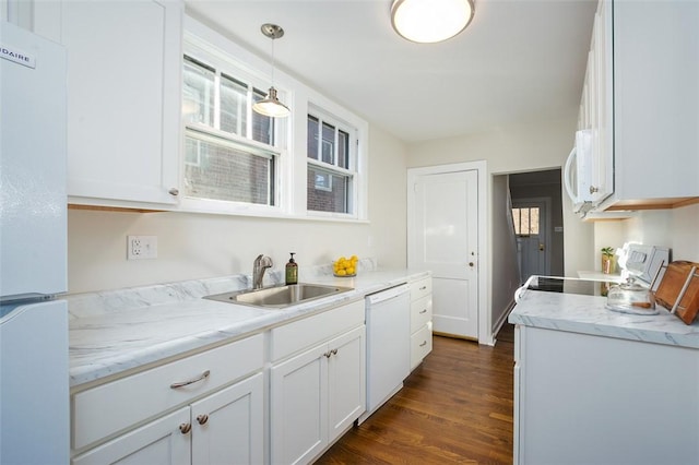 kitchen with dark wood finished floors, decorative light fixtures, white cabinets, white appliances, and a sink