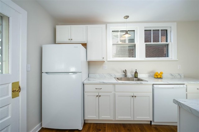 kitchen with white appliances, dark wood finished floors, a sink, pendant lighting, and white cabinetry