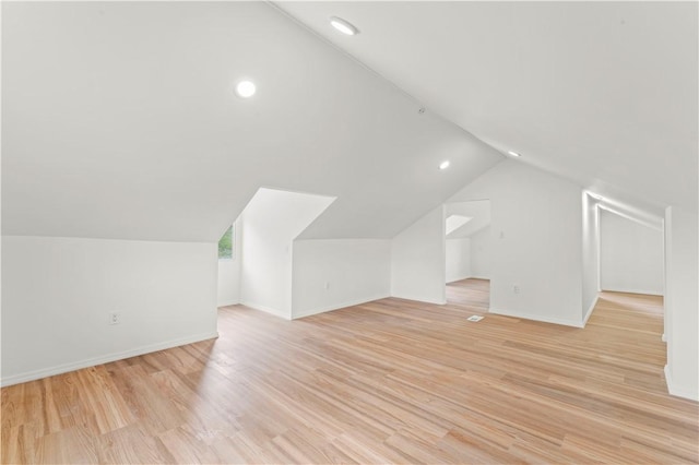 additional living space featuring recessed lighting, baseboards, lofted ceiling, and light wood finished floors