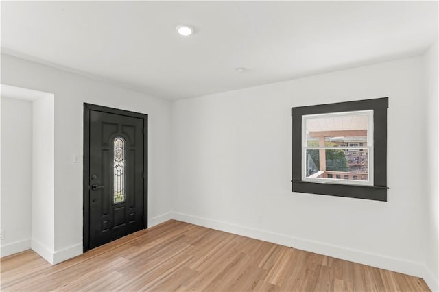 foyer entrance with baseboards and light wood-style floors