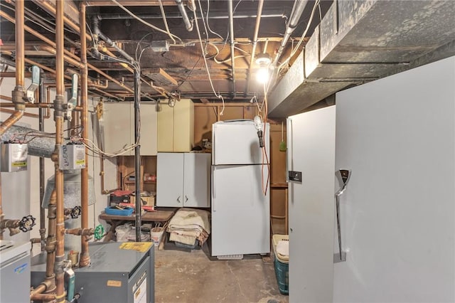 unfinished basement featuring a heating unit and freestanding refrigerator