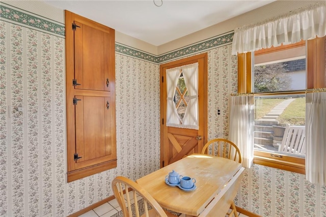 dining space with plenty of natural light, wallpapered walls, and baseboards