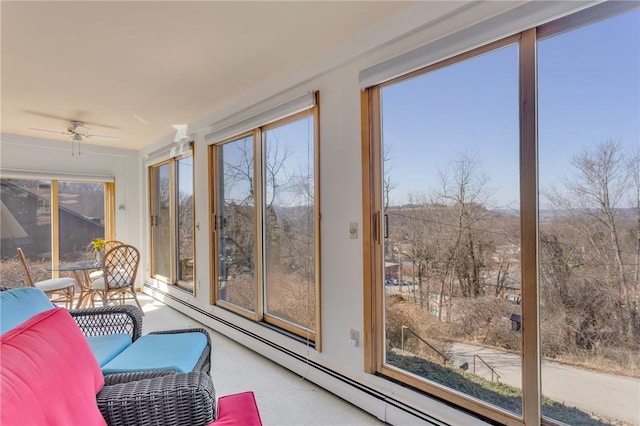 sunroom / solarium with plenty of natural light, a ceiling fan, and baseboard heating