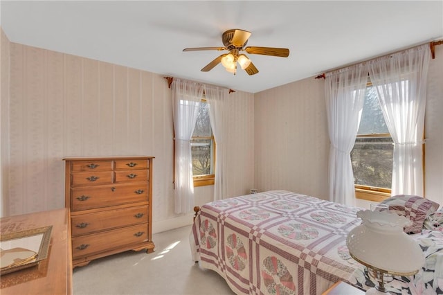 bedroom featuring light carpet, ceiling fan, and wallpapered walls