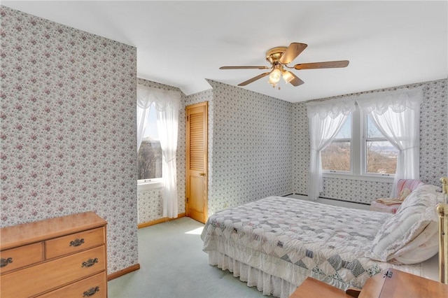 bedroom with light colored carpet, wallpapered walls, baseboards, and a ceiling fan