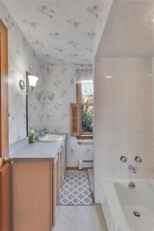 full bath with a tub to relax in, wallpapered walls, a baseboard radiator, baseboards, and vanity