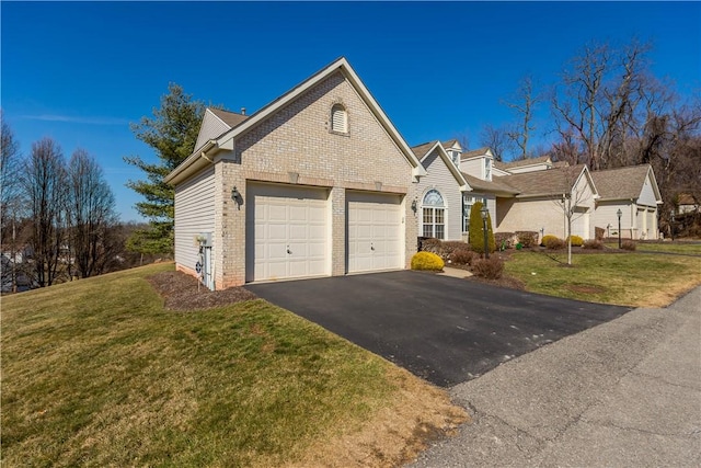 view of front facade featuring aphalt driveway, brick siding, a garage, and a front yard