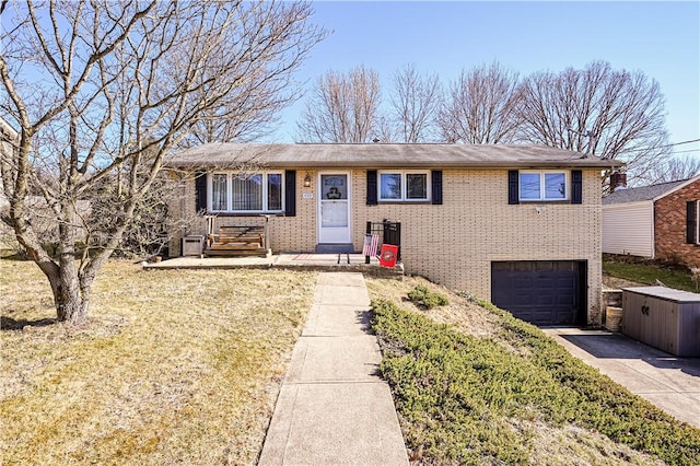 view of front of house with a garage, brick siding, and driveway