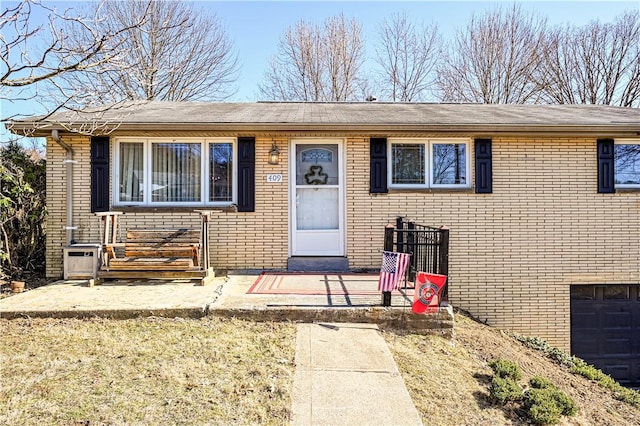 view of front of home with an attached garage and brick siding