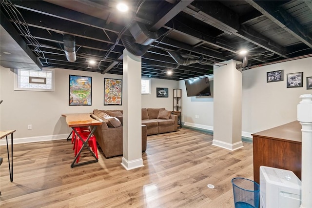 below grade area featuring plenty of natural light, baseboards, and wood finished floors