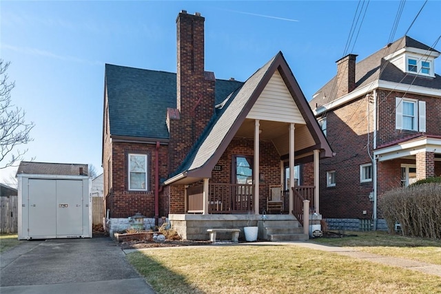 view of front of home featuring a storage shed, covered porch, an outdoor structure, brick siding, and a chimney