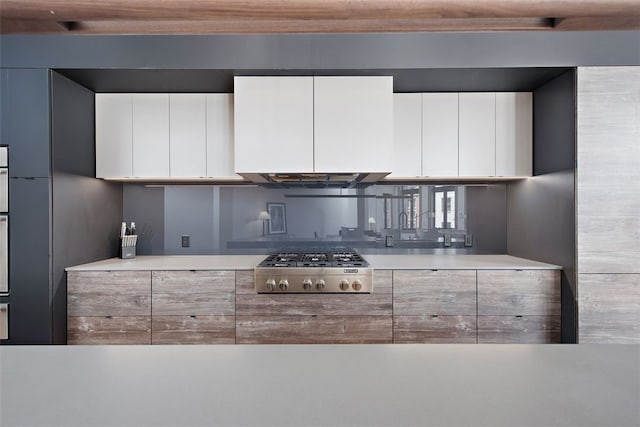 kitchen featuring white cabinets, stainless steel appliances, and light countertops