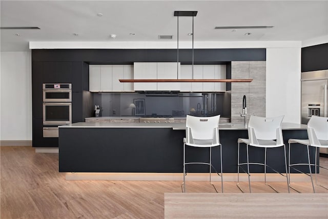 kitchen with visible vents, light wood finished floors, modern cabinets, and light countertops