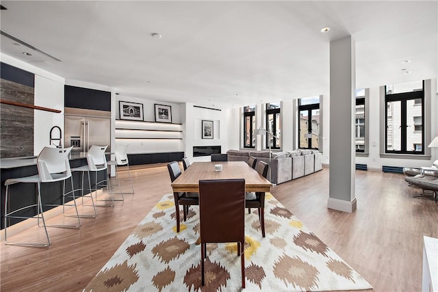 dining space featuring light wood-style flooring and baseboards