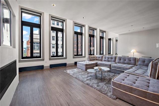 living room with recessed lighting, baseboards, and wood finished floors