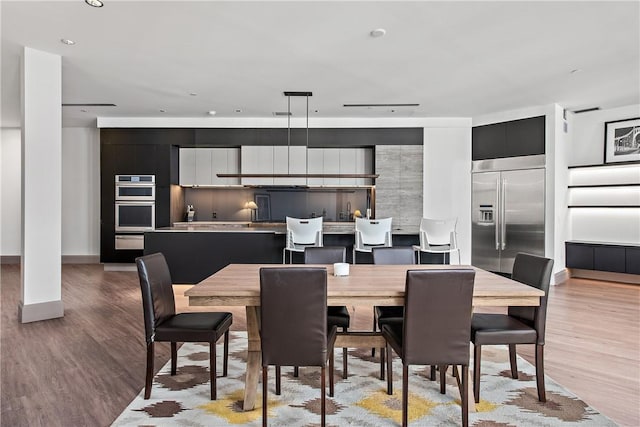 dining area with baseboards and light wood finished floors