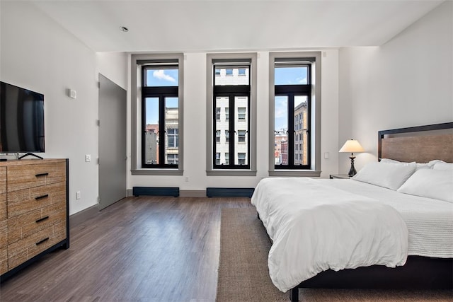 bedroom with dark wood-style floors and baseboards