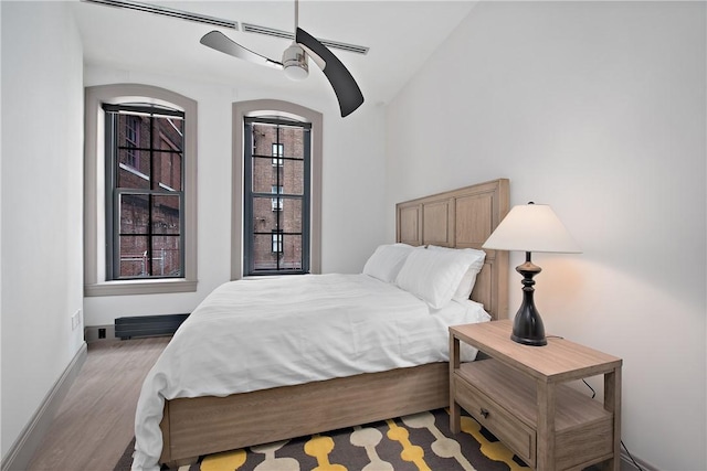 bedroom featuring light wood-style flooring, a ceiling fan, and baseboards