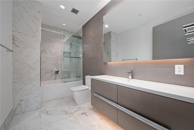 full bathroom with vanity, visible vents, tile walls, toilet, and marble finish floor