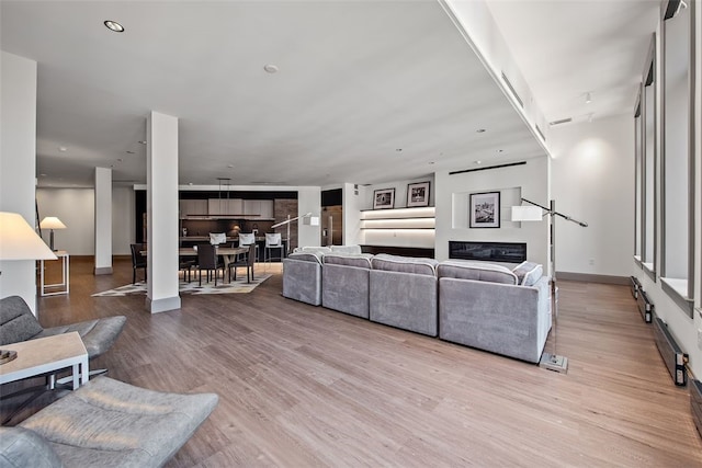 living room featuring recessed lighting, light wood-style floors, and baseboards