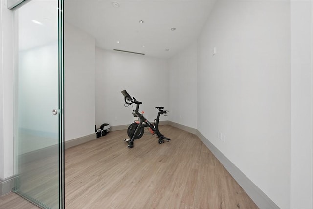 workout area with light wood finished floors and baseboards