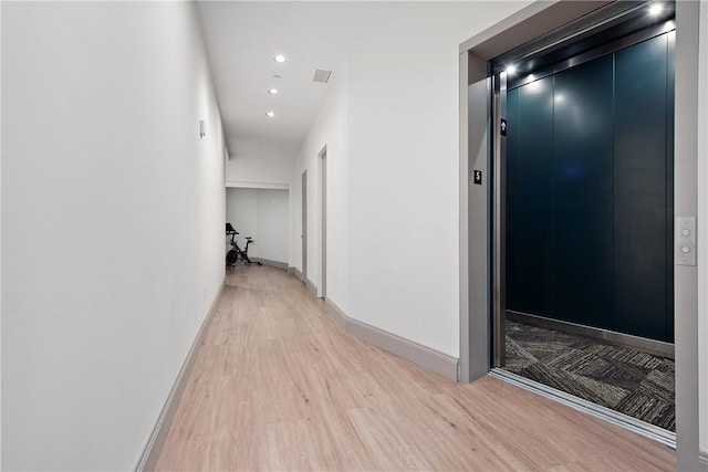 hallway featuring visible vents, recessed lighting, elevator, light wood finished floors, and baseboards