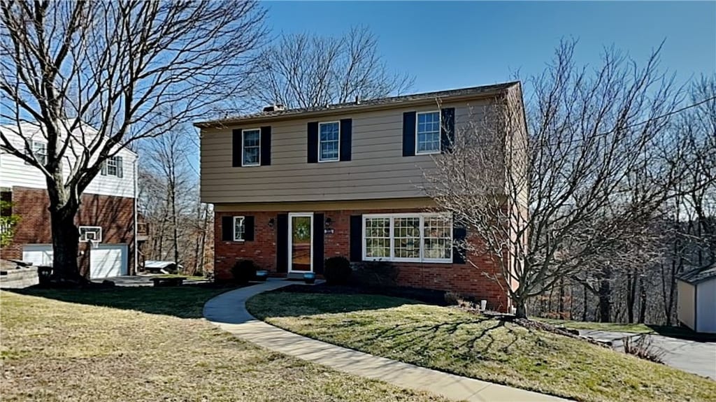 colonial house featuring brick siding and a front lawn