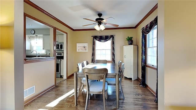 dining space featuring visible vents, dark wood-type flooring, and ornamental molding