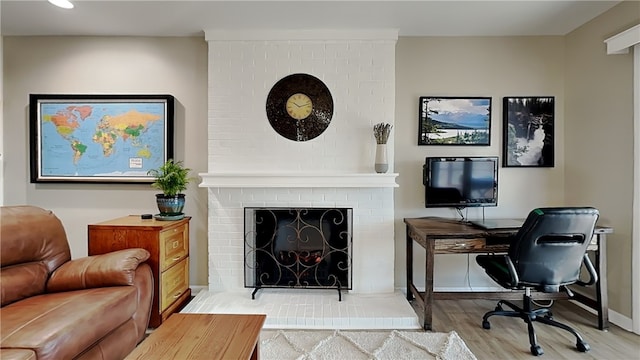 office featuring wood finished floors, recessed lighting, a fireplace, and baseboards