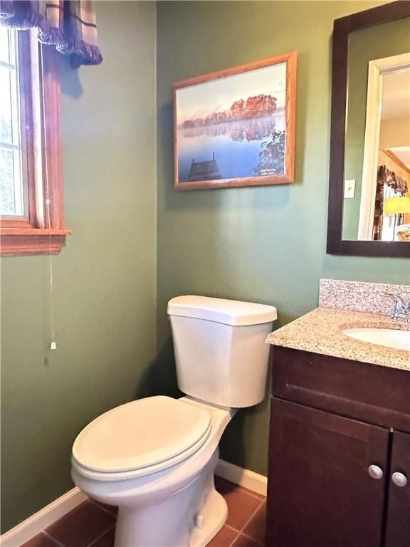 bathroom featuring baseboards, toilet, vanity, and tile patterned flooring