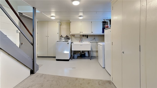 washroom featuring washing machine and dryer, cabinet space, and a sink