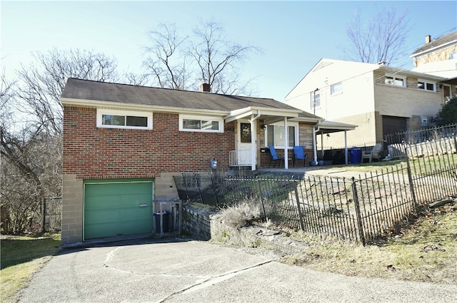 view of front of property featuring a fenced front yard, brick siding, concrete driveway, and a chimney