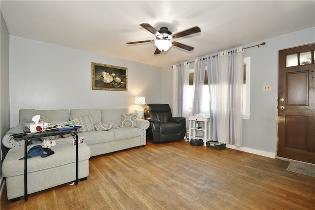 living area with ceiling fan, baseboards, and wood finished floors