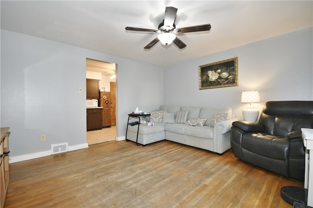 living area with a ceiling fan, light wood-style flooring, baseboards, and visible vents