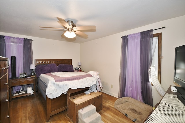 bedroom with wood finished floors, baseboards, and ceiling fan