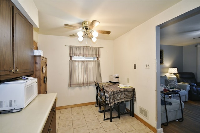 dining area featuring light tile patterned floors, visible vents, baseboards, and ceiling fan