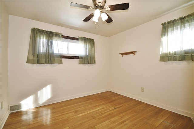 unfurnished room with ceiling fan, baseboards, visible vents, and light wood-type flooring